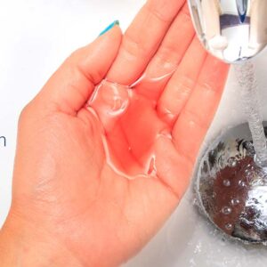 Mano de una persona debajo de un grifo de agua, una posible fuente de propagación de Legionella